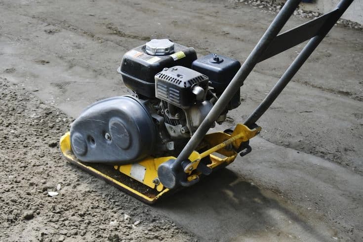 Vibratory roller compacting soil at a construction site